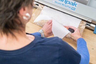 SONNENTOR Produkte aus Glas werden sorgfältig in Papier eingewickelt, damit es zu keinen Beschädigungen beim Transport kommt. | © SONNENTOR