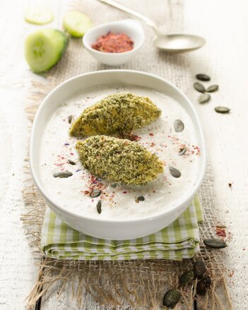 Auf dem Foto ist ein Teller mit Gurkensuppe zu sehen. Darin sieht man zwei große Tofunockerl und Kürbiskerne. | © SONNENTOR