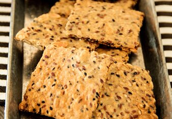 Auf dem Foto ist eine Schale mit Knäckebrot zu sehen. Darin sind viele Samen und Körner zu erkennen. | © SONNENTOR