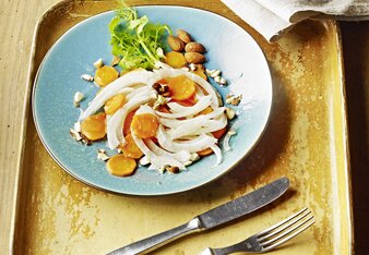 Auf dem Foto ist ein Teller mit Karotten-Fenchel-Salat zu sehen. Dahinter sieht man ein kleines Fläschchen Öl. | © SONNENTOR