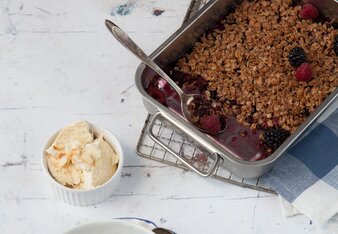 Auf dem Foto ist eine Schale mit Beeren Crumble zu sehen. Dahinter sieht man eine Backform ebenfalls mit Beeren Crumble. | © SONNENTOR