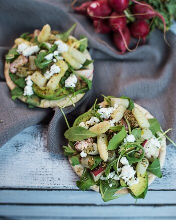 Auf dem Foto sieht man zwei Pita Brote mit Spargel, Avocado und Pesto. Daneben sieht man frische Radieschen. | © SONNENTOR