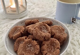 Auf dem Foto ist eine Schale Snickerdoodles zu sehen. Dahinter sind eine Tasse Tee und ein Teelicht zu sehen. | © SONNENTOR