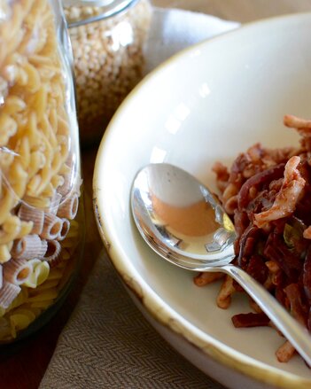 Auf dem Foto ist ein Teller mit Pasta zu sehen. Daneben sieht man zwei große Glasgefäße mit Pasta darin. | © SONNENTOR