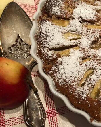 Auf dem Foto ist ein Apfelkuchen zu sehen. Daneben sieht man einen Tortenheber und einen frischen Apfel. | © SONNENTOR