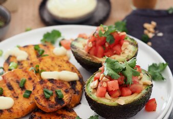 Auf dem Foto sieht man Süßkartoffelscheiben. Daneben sieht man eine gefüllte Avocado. | © SONNENTOR