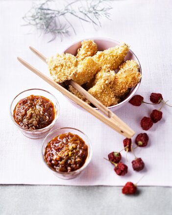 Auf dem Foto ist eine Schüssel mit Fischnuggets zu sehen. Daneben stehen Schälchen mit Tomatenchutney. | © SONNENTOR