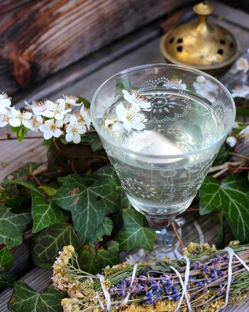 Auf dem Foto sieht man ein Glas mit Waldmeisterbowle. Das Glas ist von Efeu umgeben. | © SONNENTOR