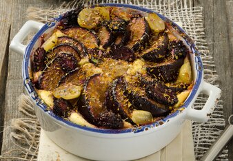 Auf dem Foto ist ein Topf mit Früchten im Topfenmantel zu sehen. Neben dem Topf sind Brombeeren, ein Schneebesen und Gewürze zu sehen. | © SONNENTOR