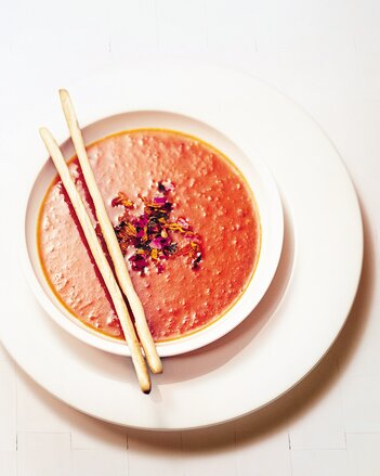 Auf dem Foto sieht man einen Suppenteller mit Tomatensuppe. Darin sind die Scharfmacher Gewürzblüten zu sehen. | © SONNENTOR