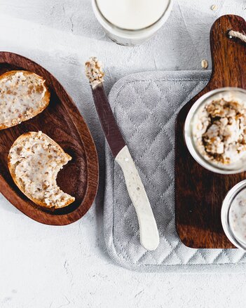 Auf dem Foto sieht man zwei Brote mit veggie Zwiebelschmalz darauf. Daneben steht eine kleine Schale mit Zwiebelschmalz. | © SONNENTOR