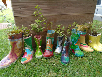 Auf dem Foto sieht man Gummistiefel, die zu Blumentöpfen umfunktioniert wurden. | © SONNENTOR
