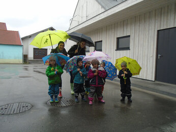 Auf dem Foto sieht man die Kinder mit Regenschirmen. | © SONNENTOR