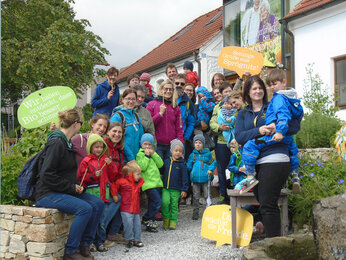 Auf dem Foto sieht man die Kinder mit ihren Eltern im Kräutergarten. | © SONNENTOR