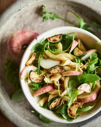 Auf dem Foto ist eine Schüssel mit Nudelsalat zu sehen. Darin sieht man auch gegrillte Zucchinistücke. | © SONNENTOR