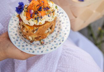 Auf dem Foto ist ein Marillen Biskuitrollen-Küchlein zu sehen. Darauf ist Zitronencreme. Darüber sind Blüten gestreut. | © SONNENTOR