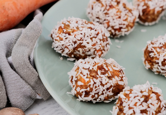 Auf dem Foto sind mehrere Energy-Balls zu sehen. Daneben sieht man Karotten. | © SONNENTOR