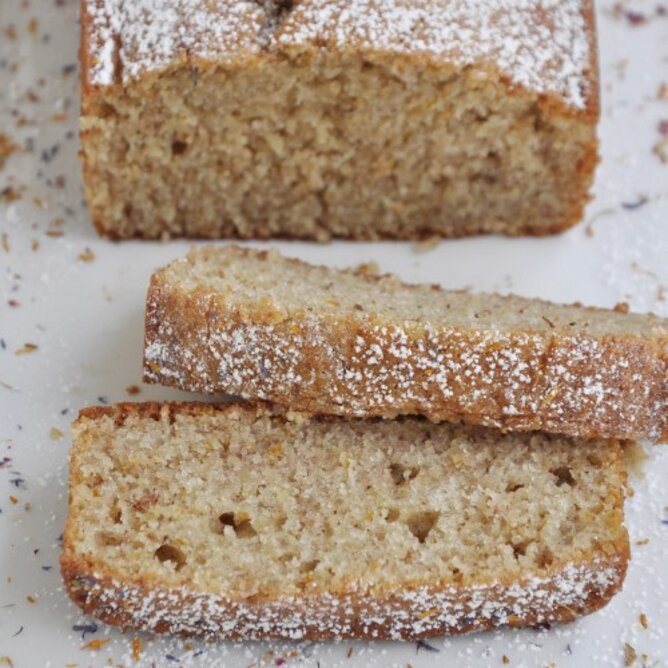 Auf dem Foto ist ein aufgeschnittenes Bananenbrot zu sehen. Es ist mit Staubzucker bestreut. | © SONNENTOR