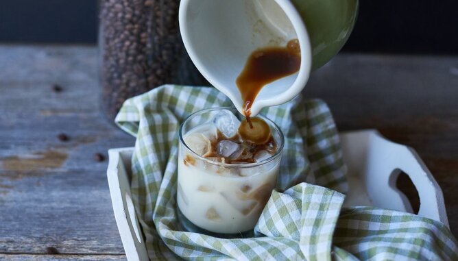 Auf dem Foto sieht man wie Kaffee in ein Glas mit Eiswürfeln gegossen wird. | © SONNENTOR