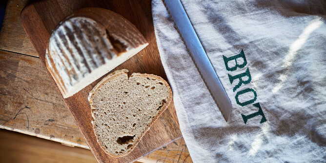 Auf dem Foto ist ein halber Laib Brot zu sehen. Davon wurde eine Scheibe abgeschnitten. | © SONNENTOR