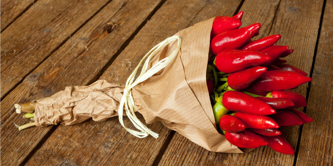 Auf dem Foto ist ein Strauß mit Chilis zu sehen. Er ist wie ein Blumenstrauß mit Papier umhüllt. | © SONNENTOR