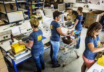 Auf dem Foto sieht man vier der Sonnentor Mitarbeiterinnen bei unterschiedlichen Verpackungstätigkeiten. | © SONNENTOR