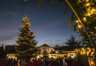 Auf dem Foto ist ein Adventmarkt zu sehen. Es befinden sich viele Personen am Adventmarkt. | © SONNENTOR